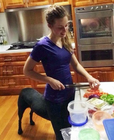 woman blends into black dog behind her