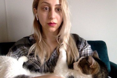 women cradles cat during zoom chat