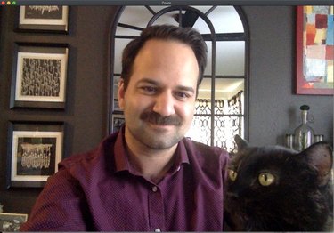 cat sits on professor's lap during online class