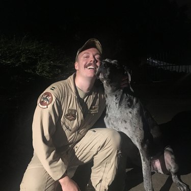 Dog cuddles with soldier