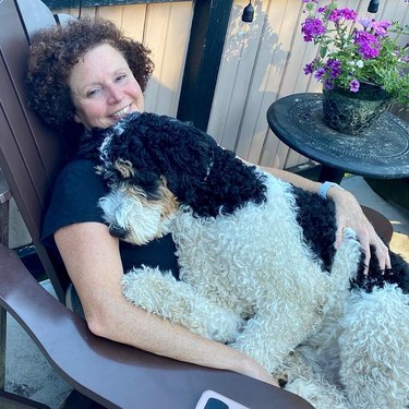 woman cuddles with big dog