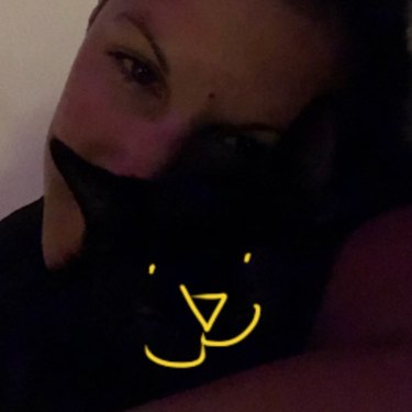 woman adds filter to black cats face so it's visible in picture