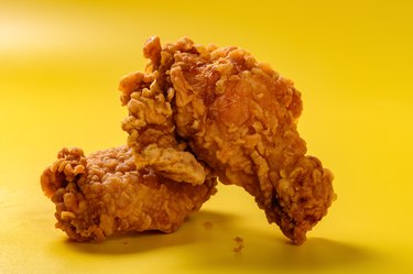 side view fresh deep fried chicken drumstick and wing on yellow background