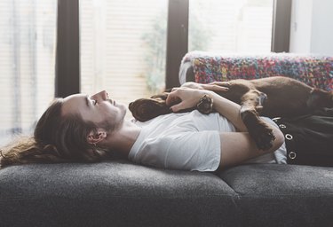 Teen napping on the sofa with dog
