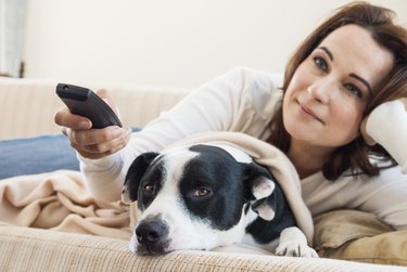 Woman watching television with dog