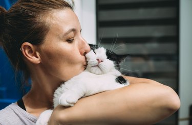 Woman holding and kissing her cat