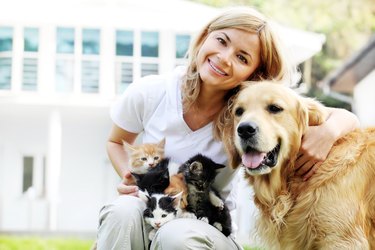 Woman enjoying the outdoors with kittens and dog