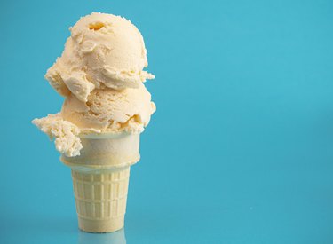 Double Scoop Vanilla Ice Cream Cone on a Blue Background