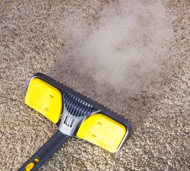 Close-up of dry steam cleaner cleaning a carpet