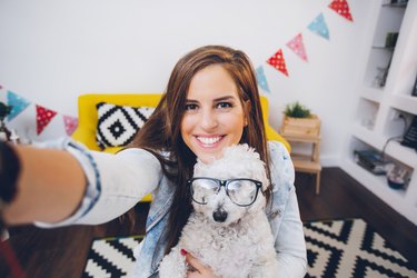 woman posing with cute dog wearing glasses