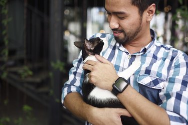 Man cuddling a cat.