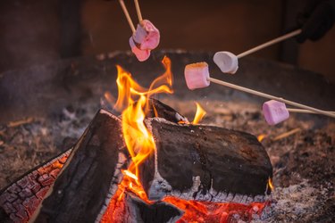 Toasting a marshmallow over an open flame at Christmas market winter wonderland in London