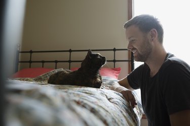 Man and cat face to face in bedroom