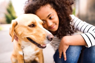 Beautiful african american girl walking with her dog.