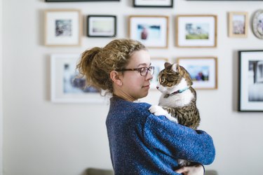Face to face between a girl and her tabby cat