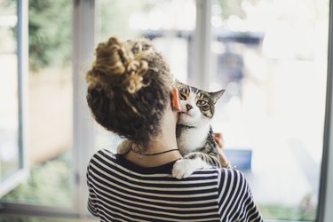 A teenage girl holding her cat