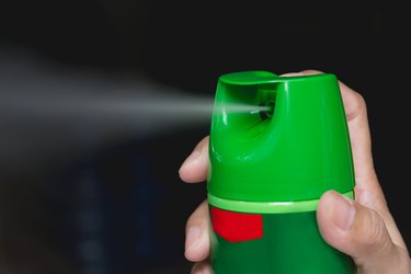Close-Up Of Hand Holding Green Spraying Bottle