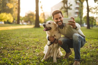 man taking selfie with dog outdoors