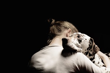girl embracing her dog, studio shot