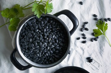 Directly above shot of black beans in cooking pan on tablecloth