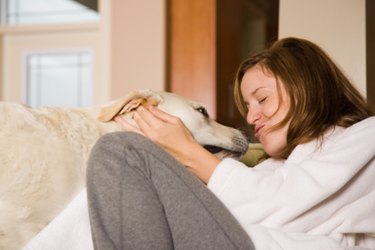 Woman snuggling with large white dog.