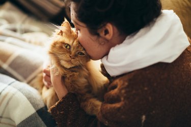 Woman kissing cat