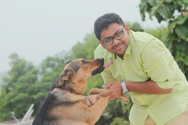 Portrait Of Man With Dog Standing Against Sky