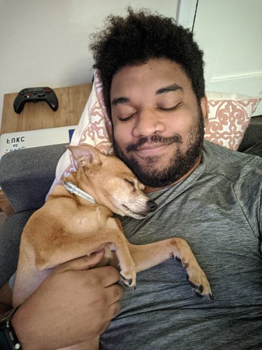 man and dog sleep on couch