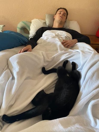 man and cat sleeping together