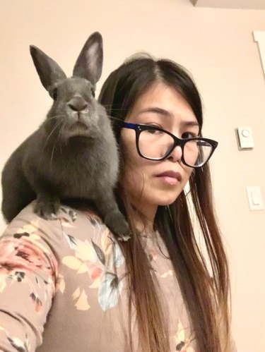 Woman with rabbit sitting on shoulder