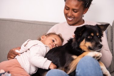 Mother and baby with their dog at home.