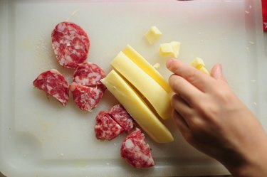Taking cheese in small cubes and salami slices