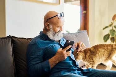 Mature male relaxing with his pet cat.