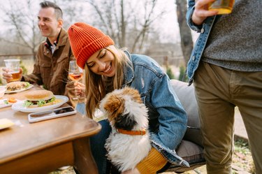 Woman hugging a dog outside at a dinner gathering