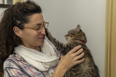 Latin American woman cuddles and plays affectionately with her cat