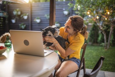 Woman with laptop working in garden