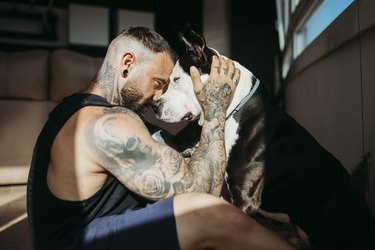 Man sitting face to face with dog at home