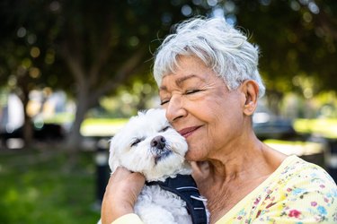 Senior woman holding her small white dog