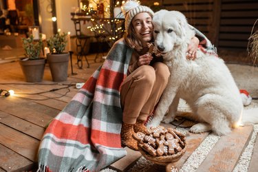Woman celebrating with dog a New Year holidays at home