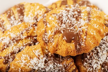 A snickerdoodle cookies topped with melted chocolate and coconut flakes.