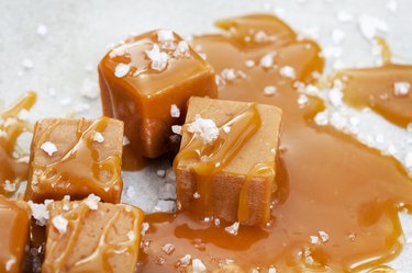 Salted caramel squares drizzled with caramel syrup and topped with coconut flakes.