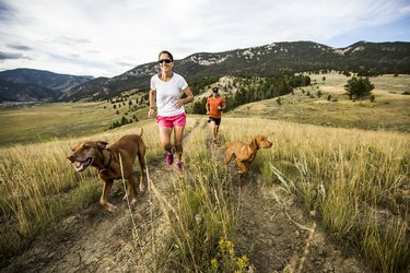 A man and woman trail running