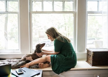 Woman sitting in window with dog