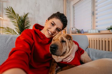 Young Woman Taking A Selfie With Her Dog At Home