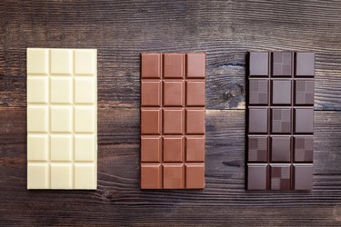 Delicious chocolate bars on wooden background