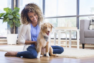 Woman relaxing at home with adorable puppy