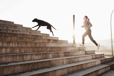 Young woman running up steps with dog