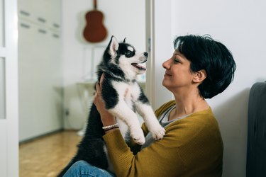 Woman holding a puppy at home