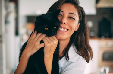Woman hugging her black cat