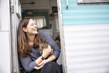 Woman camping in a trailer with her cat